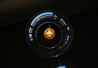 Two glass pendant light bulbs hanging from a dark ceiling, dimly lit interior.