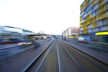 Fast motion perspective of tram tracks through a city, giving a dynamic sense of speed and movement.