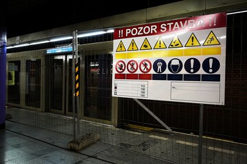 Subway station under construction with warning signs and barriers, evoking a sense of restriction.