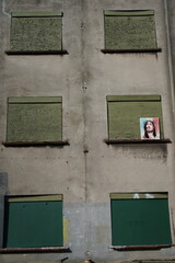 Abandoned Building Facade with Boarded Windows and Image of Jesus Christ &ndash; Urban Decay and Religious Symbolism in a Derelict Setting