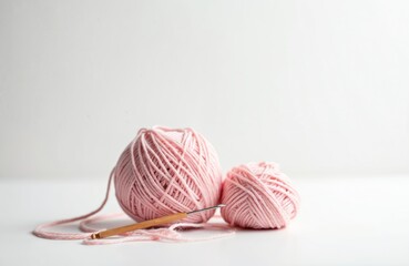 Pink yarn balls, crochet hook on white background. Crafting, needlework hobby. Knitting wool balls, craft tools, handicraft material, creative leisure activity. Pink color, handicraft. Close-up