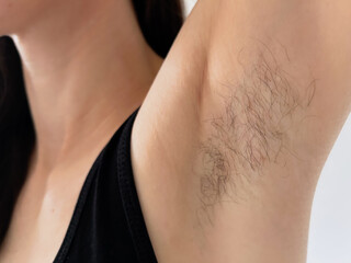 Close-up of female armpit with natural body hair – body positivity and self-acceptance concept