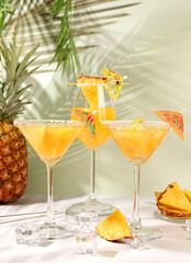 Various alcoholic cocktails with slices of mango, pineapple and ice in glasses with rims and umbrellas. Concept of a tropical party and relaxation. Advertising business card for a bar  menu.