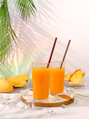Fresh pineapple smoothie or juice with pineapple and mango slices, modern still life with tropical fruits. Summer vacation and detox diet concept. Flyer for a cafe or restaurant, summer postcard