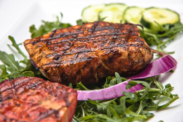 Fried fish fillet with arugula and red onion on a white background, dorado fish, food