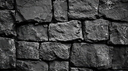 Textured black stone wall featuring aged rock blocks, ideal for interior design and decoration backgrounds. Suitable for various creative projects.