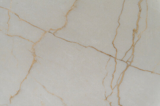 Marble texture with thin golden veins in warm tones