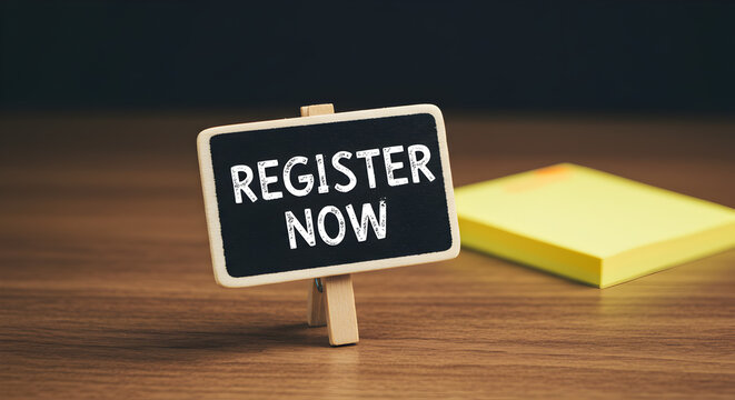 Register Now Message on Small Black Chalkboard Against Dark Background