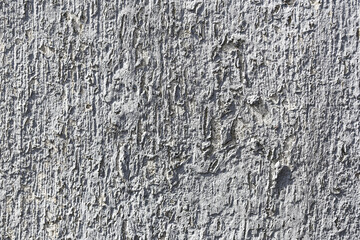 Rough concrete surface detail. Gray wall texture closeup. Weathered plaster background. Raw cement structure. Industrial building material. Grunge pattern wall. Hard construction surface.