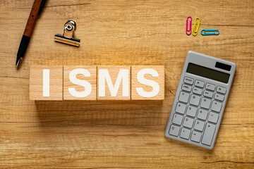 There is wood cube with the word ISMS. It is an abbreviation for Information Security Management...
