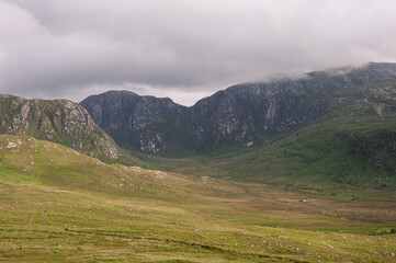 A mountain range with a cloudy sky in the background