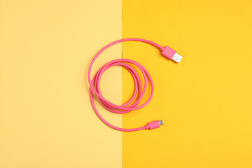 One USB charge cable on color background, top view