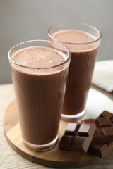Tasty chocolate milk and bars on wooden table, closeup