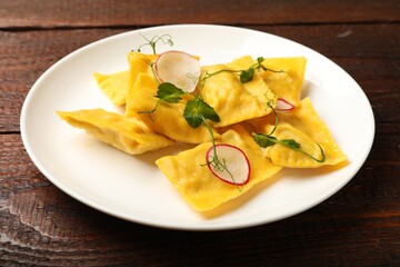Delicious ravioli with microgreens and radish on wooden table, closeup