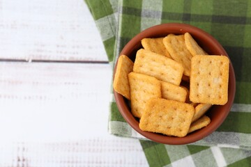 Tasty salty crackers on white wooden table, top view. Space for text
