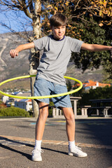 Playing with hula hoop, boy enjoying outdoor activity at school playground