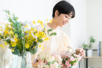 リビングでフラワーアレンジメントをする若い女性