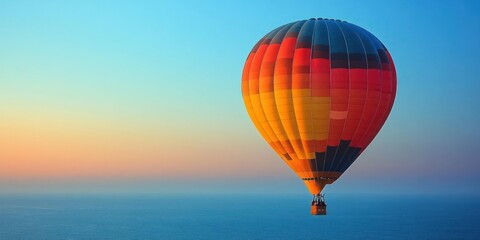 Obraz premium Colorful hot air balloon soaring above a serene sunrise landscape