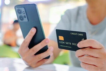 Close up female hands holding credit card and smartphone, paying online, credit card shopping, using banking service, entering information, shopping, ordering in internet store, doing secure payment