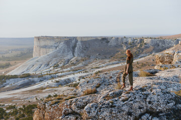 Fototapeta premium Woman standing on cliff overlooking valley and mountains travel adventure in nature landscape beauty and serenity