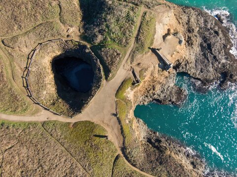 Aerial view of  a collapsed sea cave, along the coast in Mendocino, California, USA. The park is a popular tourist destination for viewing the ocean.