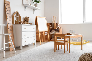 Interior of light playroom with toys and whiteboard in kindergarten