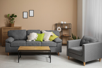 Comfortable sofa with cushions, coffee table and armchair in living room