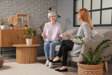 Happy teenage girl talking to psychologist in office