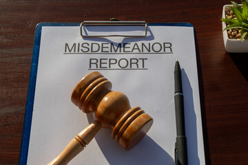 A document titled “Misdemeanor Report” secured in a clipboard and resting on the desk,...