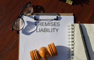 A legal document titled “Premises Liability” placed in a clipboard resting on the desk,...