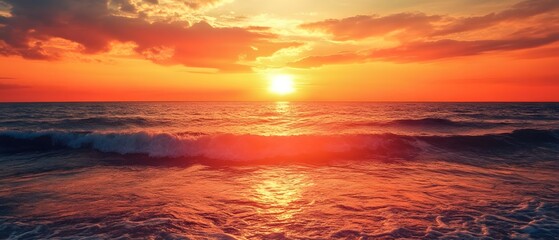 Obraz premium Ocean sunset with bright sun reflecting on water and clouds above.
