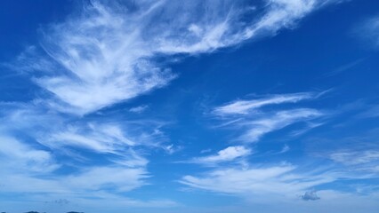 Bright Blue Sky with Soft White Clouds Floating Peacefully Over the Horizon