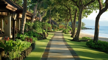 Resort walkway flanked by green lawns and tropical plants leading to the beach