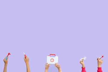 Children with toy medical supplies on lilac background