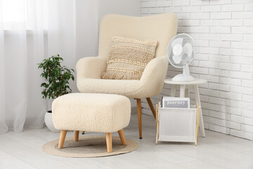 Modern electric fans on shelving unit and chest of drawers in living room