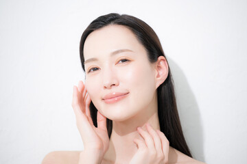 Camera-eye close-up of a beauty image of a young woman with beautiful dark hair and a beautiful hand to accompany her glossy and bare skin.