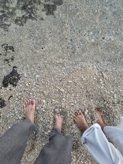 Romantic Feet Together on Sandy Beach with Clear Sea Water