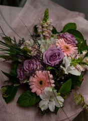 A bouquet of flowers with pink and purple flowers and green leaves