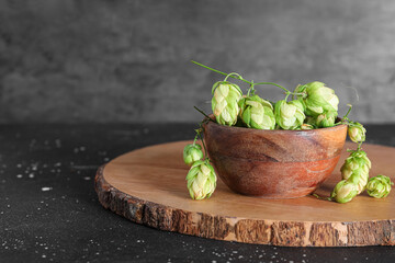 Bowl of green hops cones on black background
