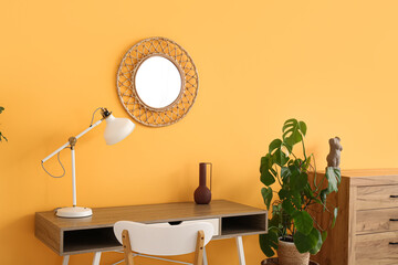 Workplace with lamp and mirror in interior of living room