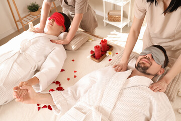 Young couple getting massage in spa salon on Valentine's Day