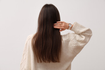 Fototapeta premium Woman with wristwatch and jewelry on white background, back view
