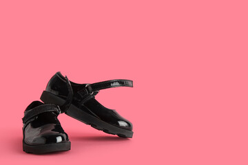 Black girl's shoes on pink background