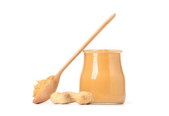 Jar with tasty peanut butter, wooden spoon and nuts on white background