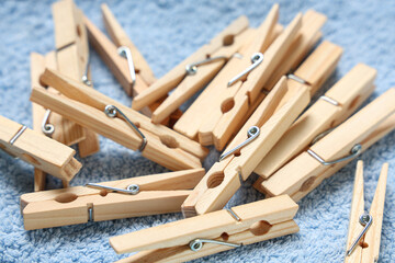 Wooden clothespins on clean towel as background, closeup