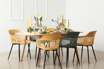 Table setting with spring flowers  near light wall in room