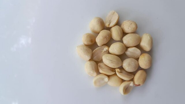 Group of peanuts or groundnuts on white colour plate.