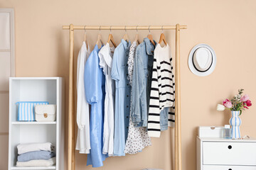 Interior of stylish dressing room with clothes rack, shelving unit and dressing table