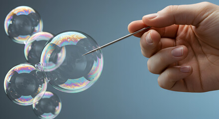 Hand Holding Needle Piercing Translucent Soap Bubbles Against Gray Gradient Background Close Up Studio Shot