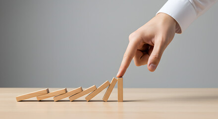 Finger Pushing Dominos in Chain Reaction on Wooden Table Business Risk Management